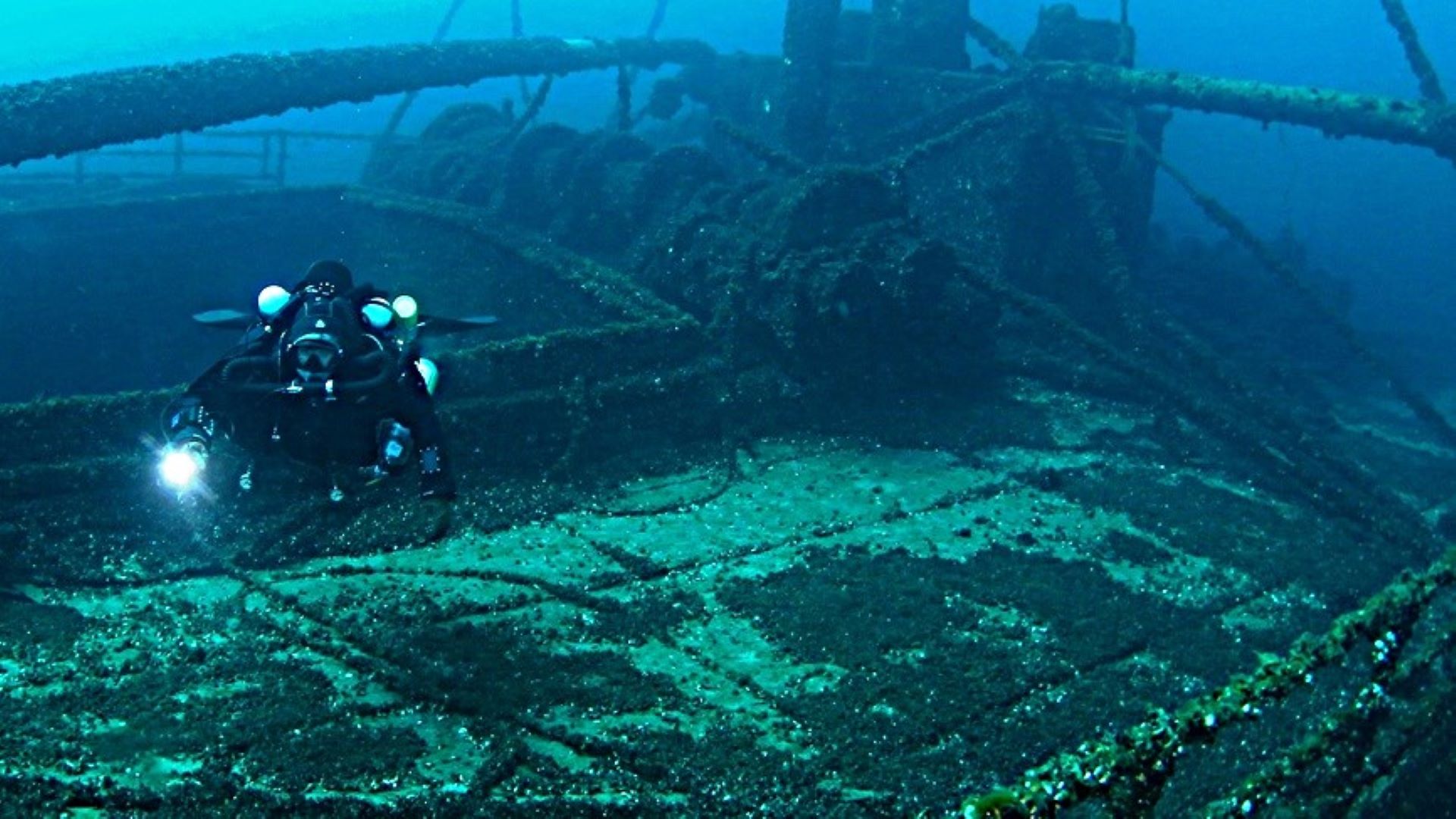 Divers hovering above fragile shipwreck structure